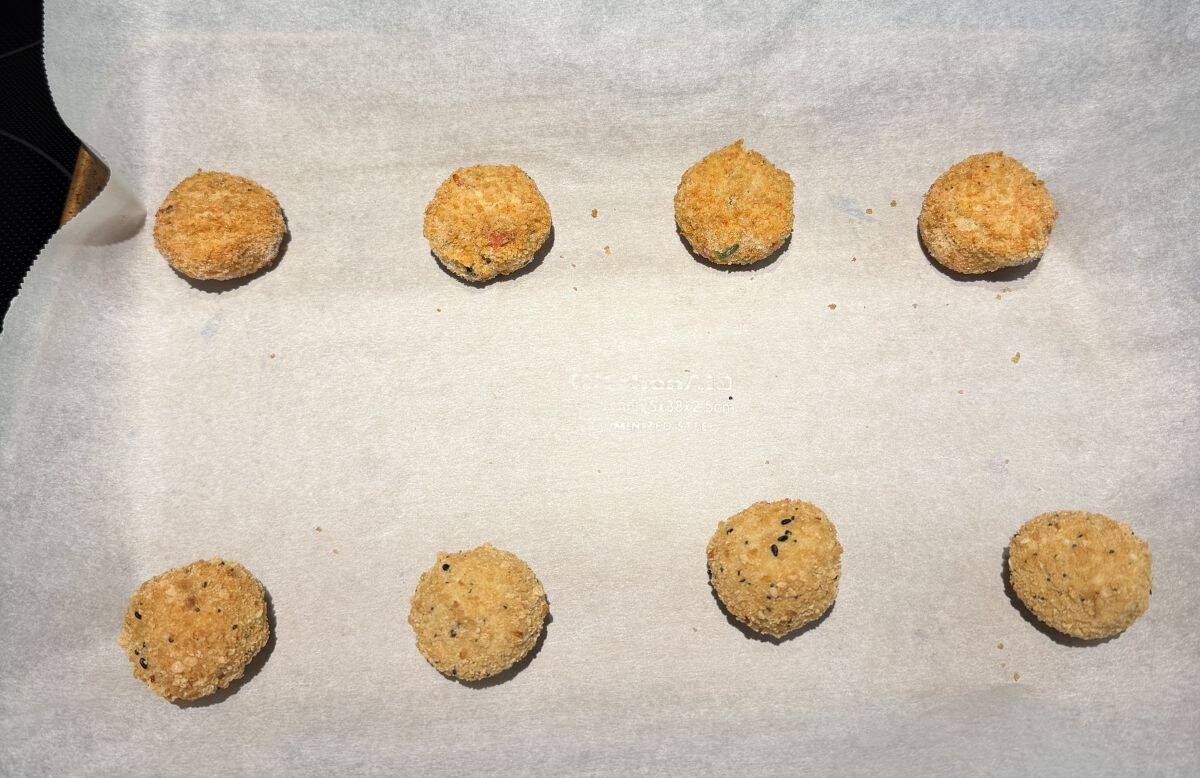Image of eight bites on a parchment paper lined cookie sheet before being baked.