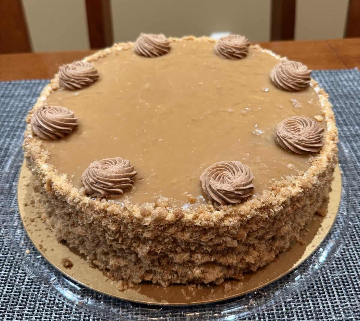 Image of the cinnamon apple cake sitting on a table with the lid off before being cut.