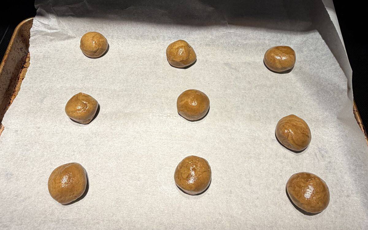 Image of gingerbread cookie dough balls before being baked on a tray.