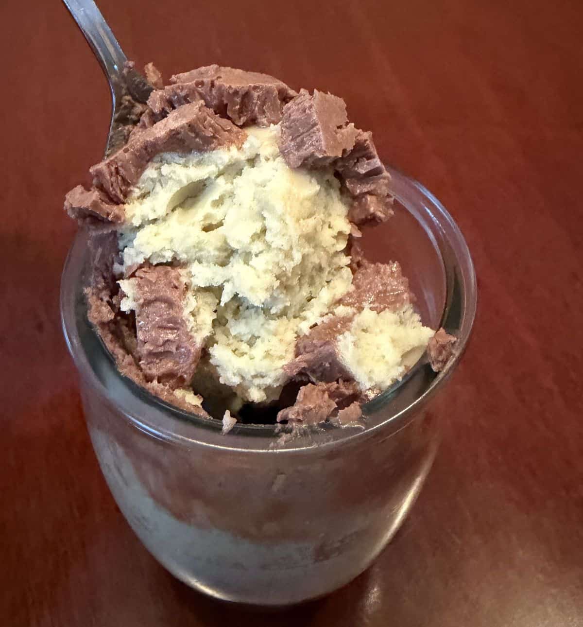 Image of a spoon lifting the some of the dessert out of the glass dish so you can see what it looks like.
