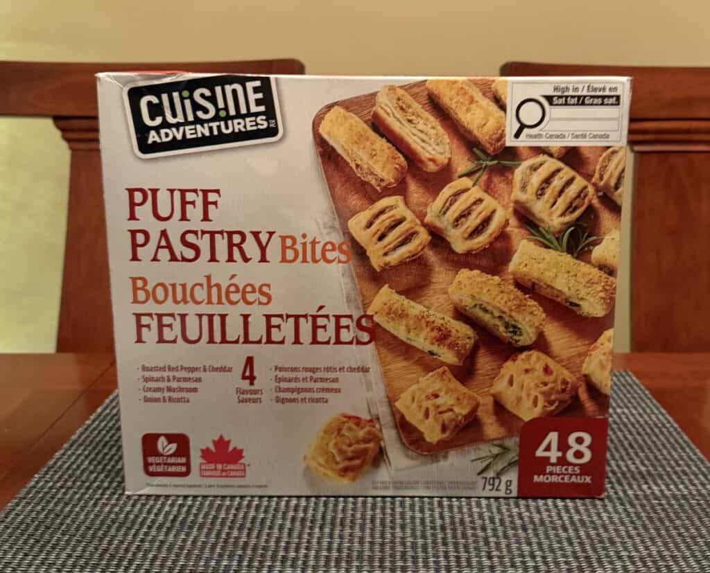Image of the Costco Cuisine Adventures Puff Pastry Bites box sitting on a table unopened.