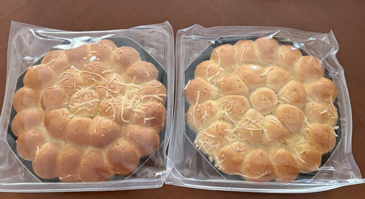 Image of two pull apart brioches plastic wrapped sitting on a table.