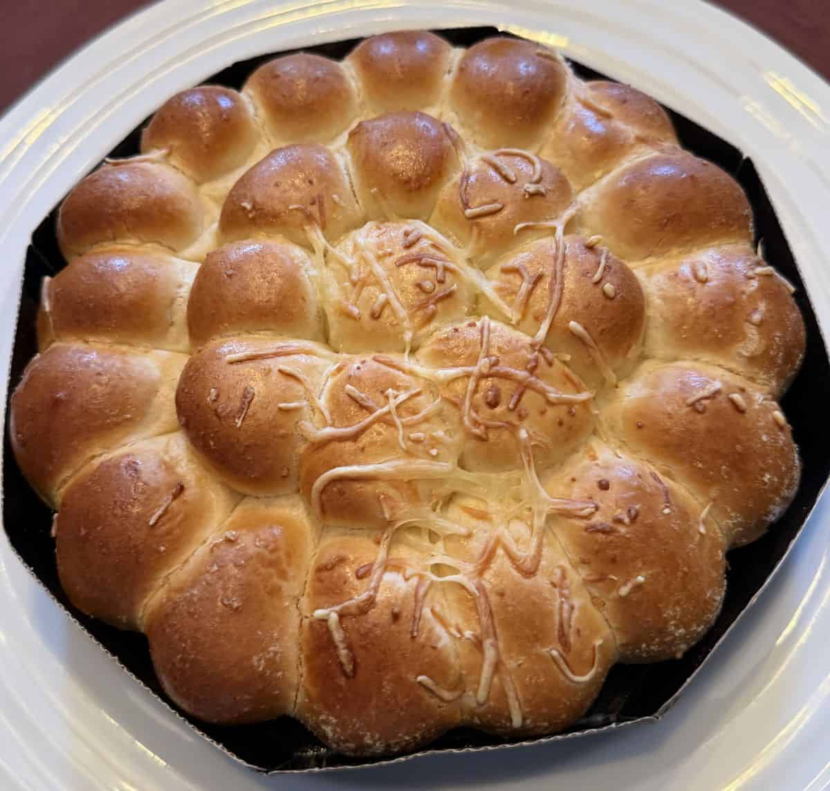 Top down image of the heated pull apart brioche served on a white plate.