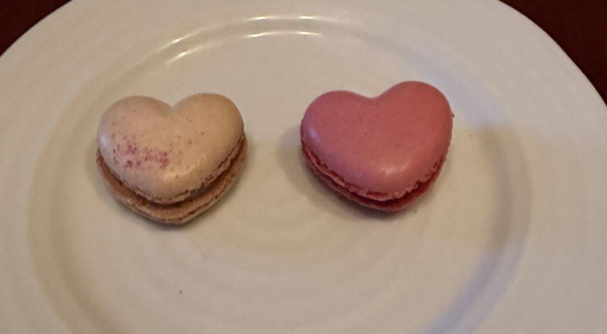 Image of two heart-shaped macarons served on a white plate.