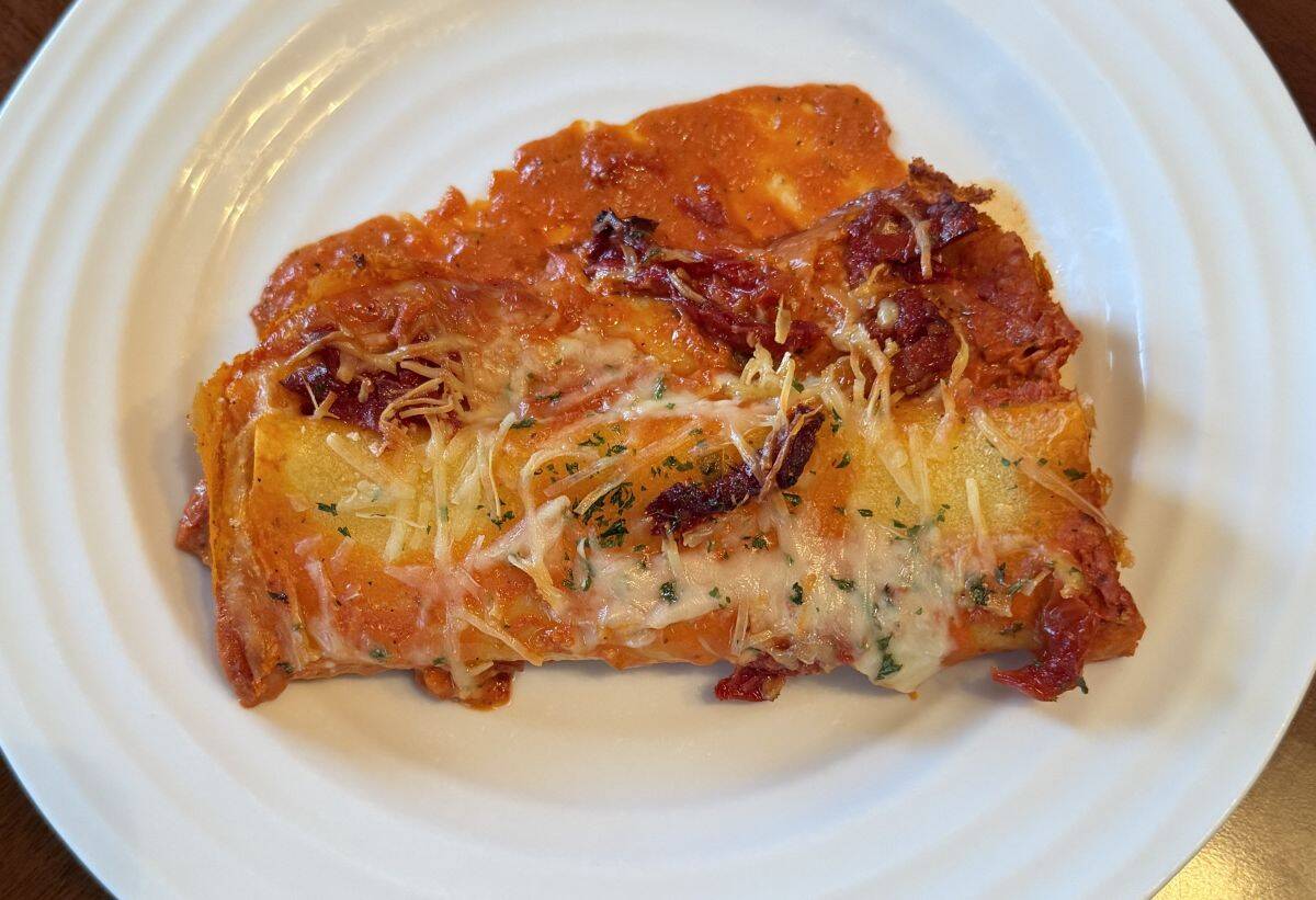 Image of two pieces of manicotti served on a white plate.