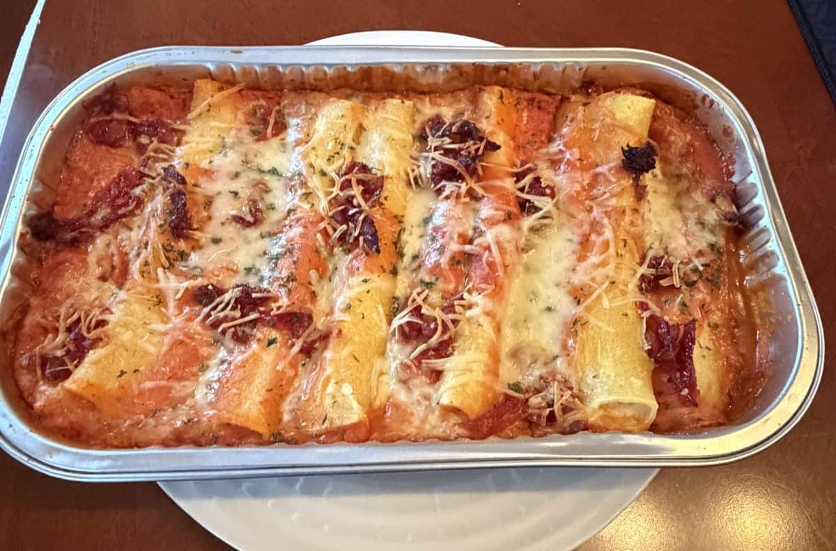 Image of the tray of manicotti, cooked, after coming out of the oven.