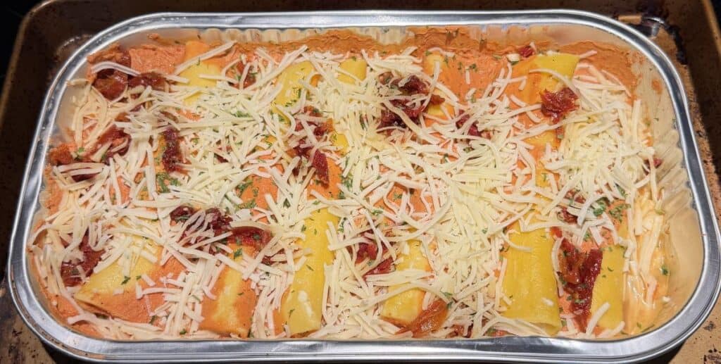 Image of the manicotti meal on a cookie tray before putting it in the oven.