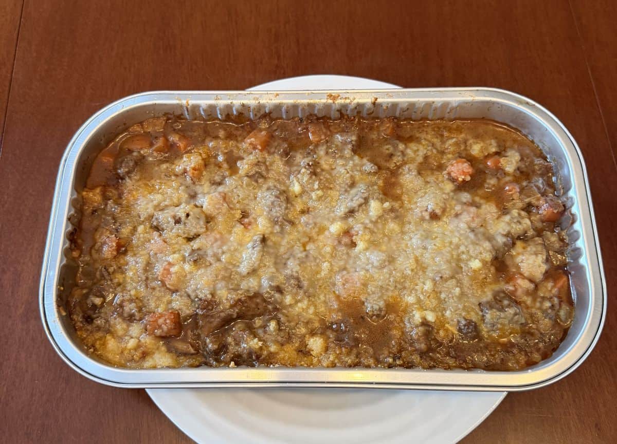 Image of the entire steak and ale potato bake cooked and sitting on a plate on a table.