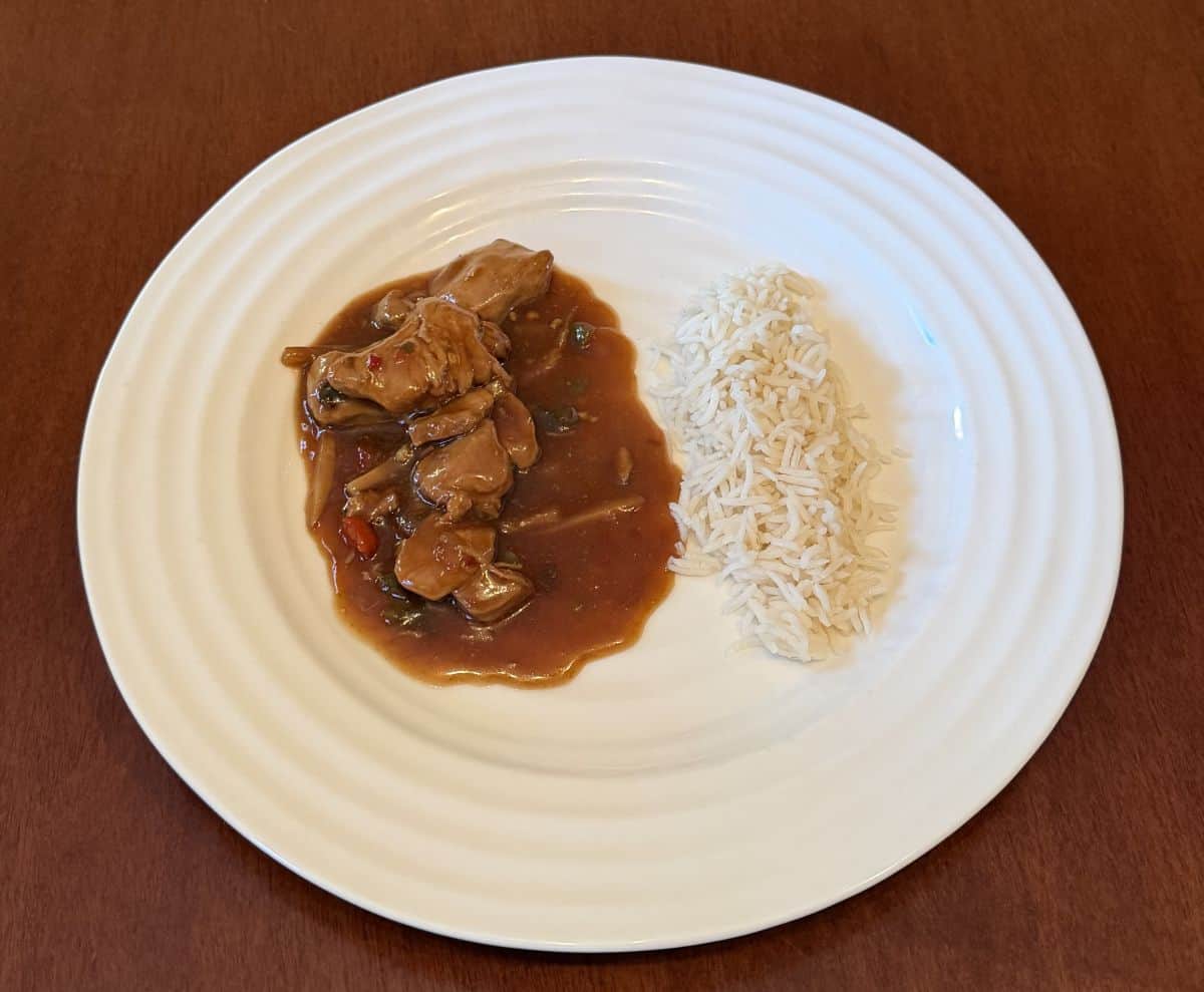 Image of the kung pao chicken served beside white rice on a plate.