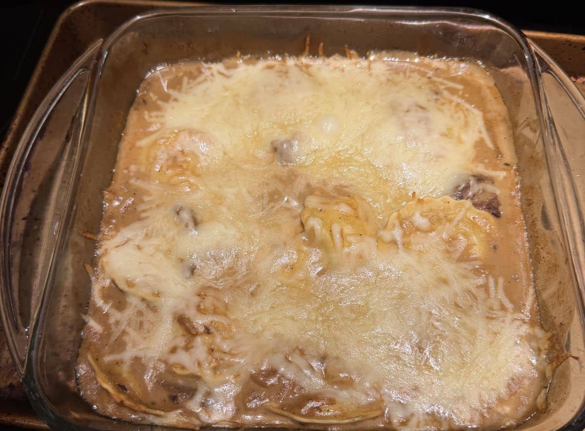 Image of the French onion style ravioli in a glass baking dish after being baked in the oven.