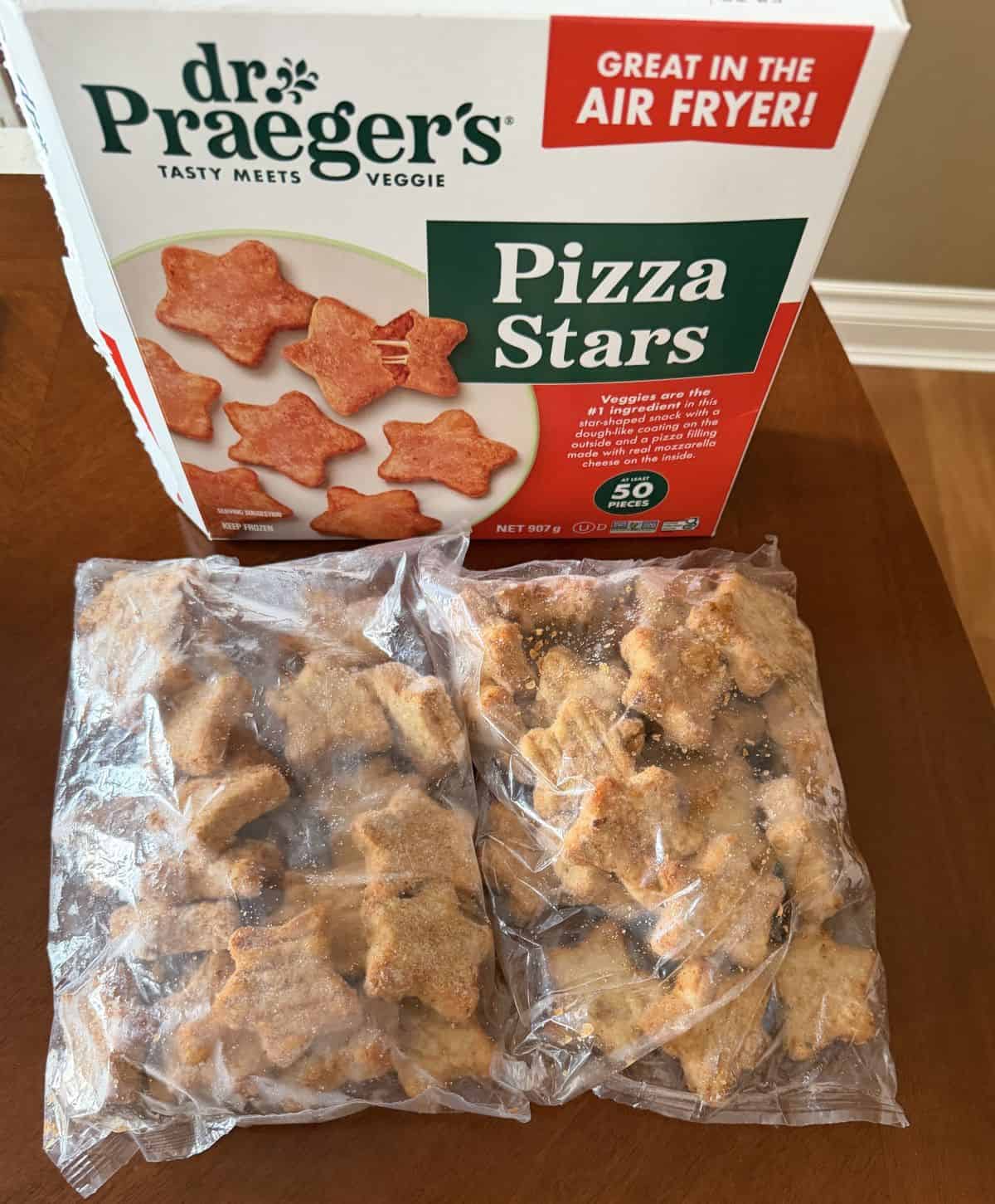 Image of two plastic bags of frozen pizza stars infront of a box of pizza stars on a table.