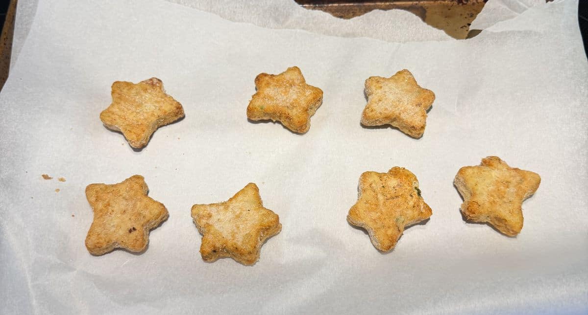 Image of the pizza stars on a parchment lined baking sheet before being heated.