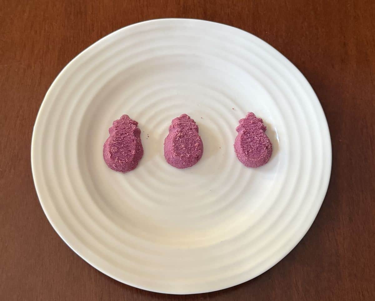 Image of three ube shortbread served on a white plate.