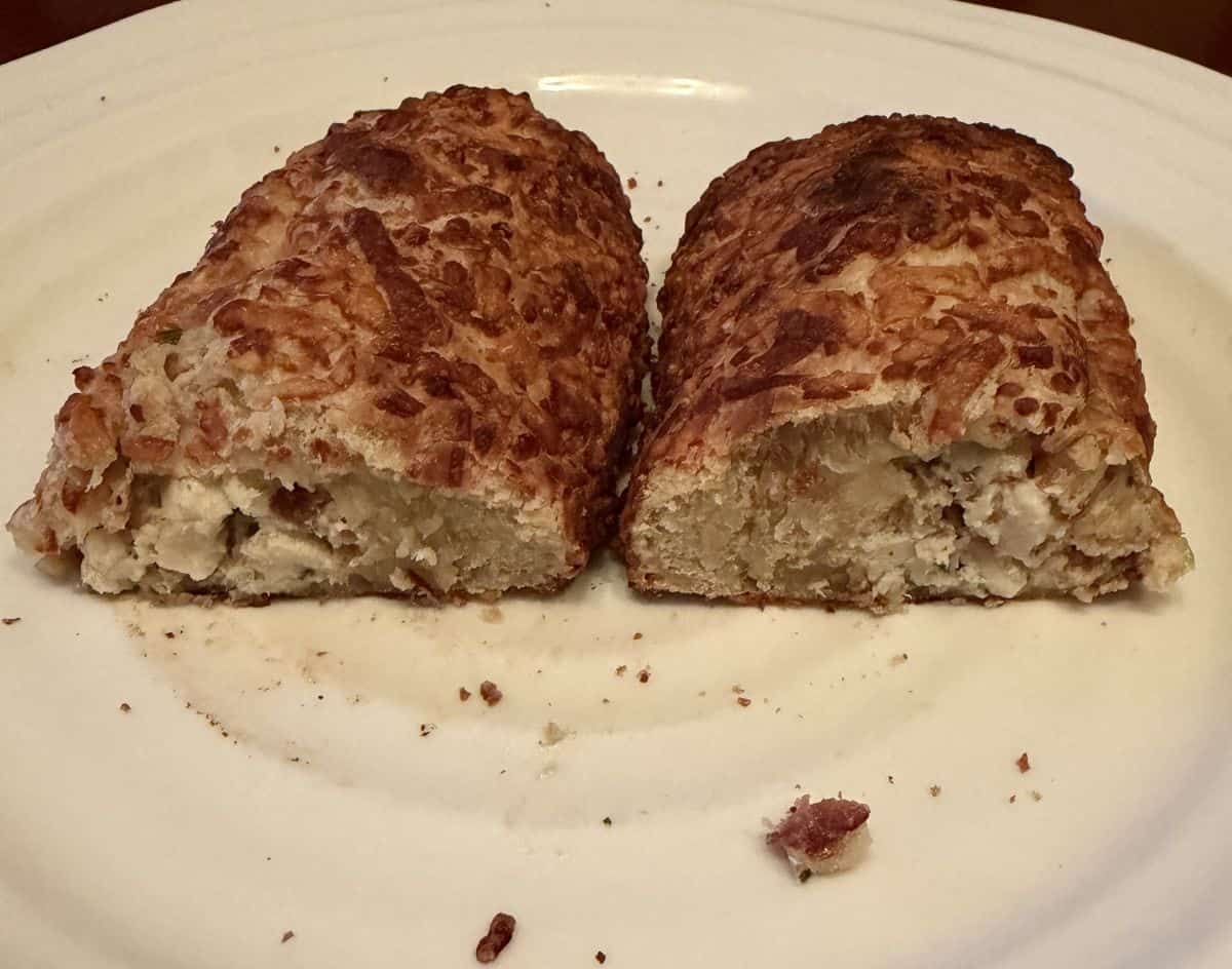 Image of two chicken bake halves sitting on a white plate so you can see the filling inside.