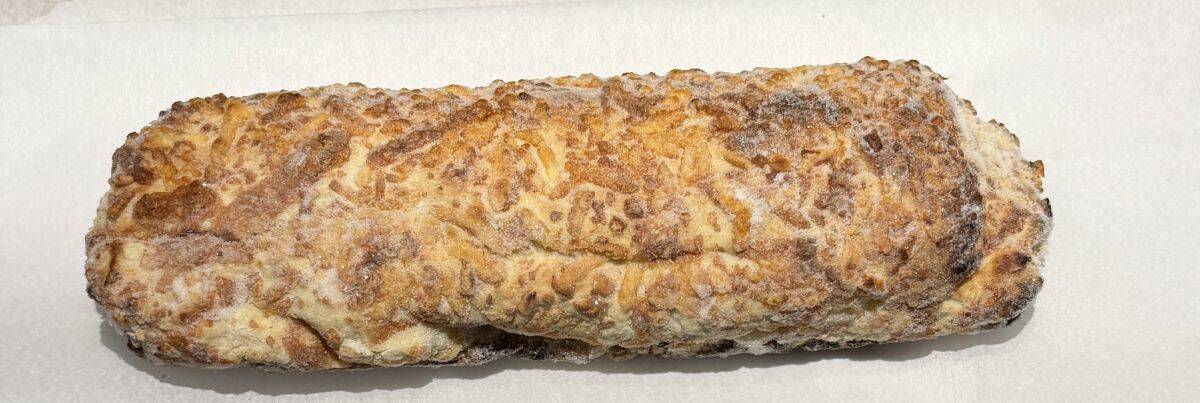 Image of a frozen chicken bake sitting on parchment paper before being put in the oven.
