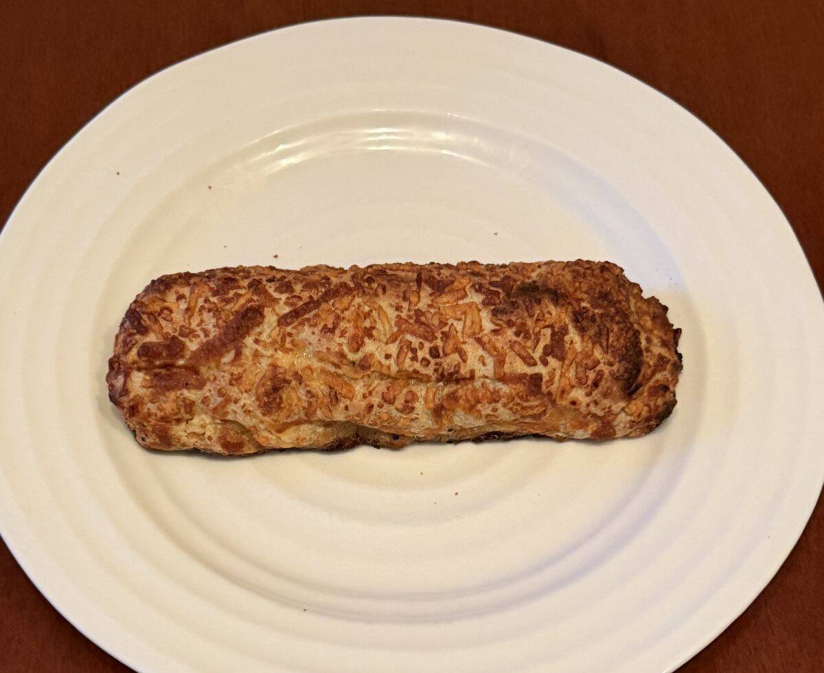 Image of one cooked chicken bake served on a white plate.