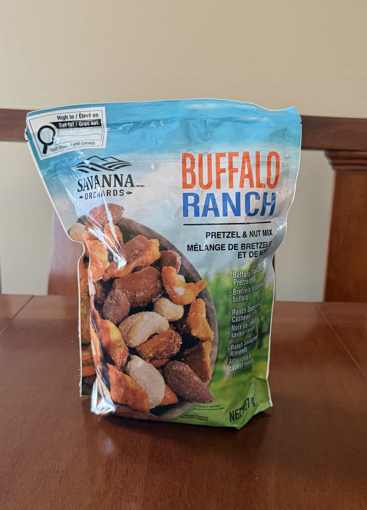 Image of the Costco Savanna Orchards Buffalo Ranch Pretzel Nut Mix bag sitting on a table unopened.