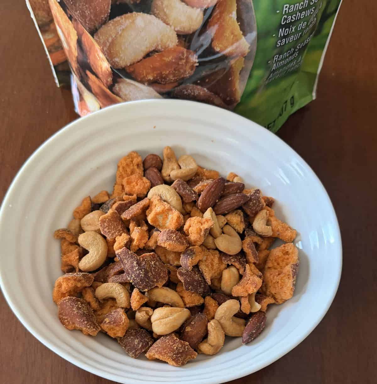 Top-down image of the pretzel nut mix served in a white bowl.
