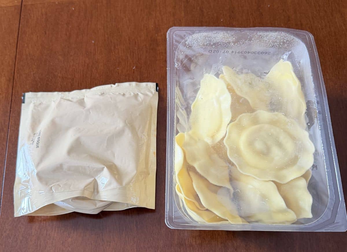Image of a package of ravioli and a pouch of sauce sitting on a table unopened.
