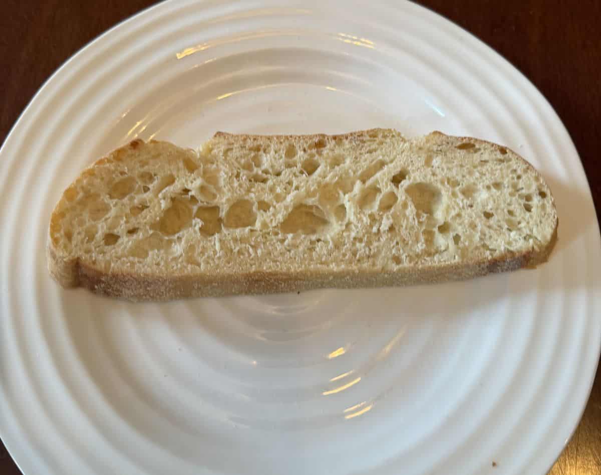 Image of one slice of the Pane Roma Sourdough served on a white plate.