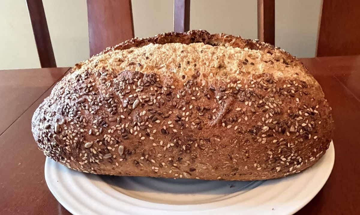 Image of the entire Wholesome Grains Sourdough loaf served on a white plate.