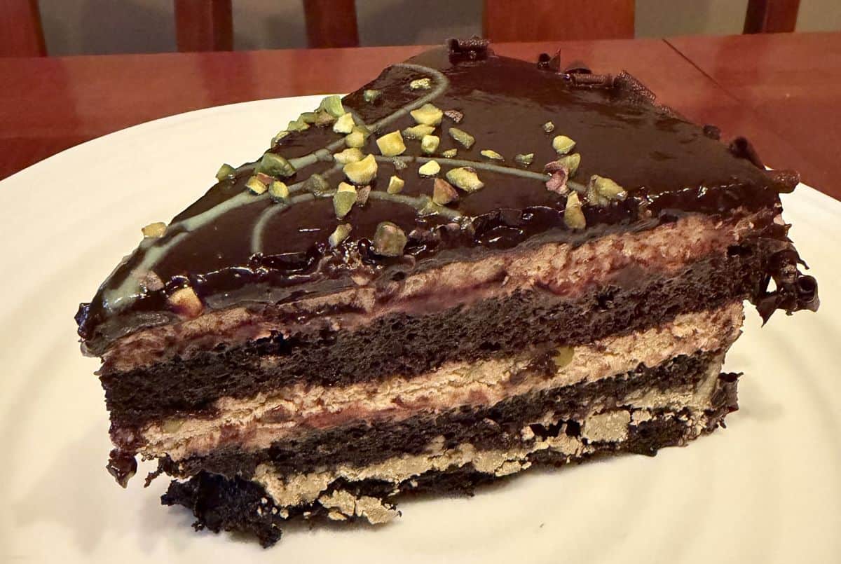 Closeup image of one slice of the Pistachio Chocolate Cake served on a white plate.