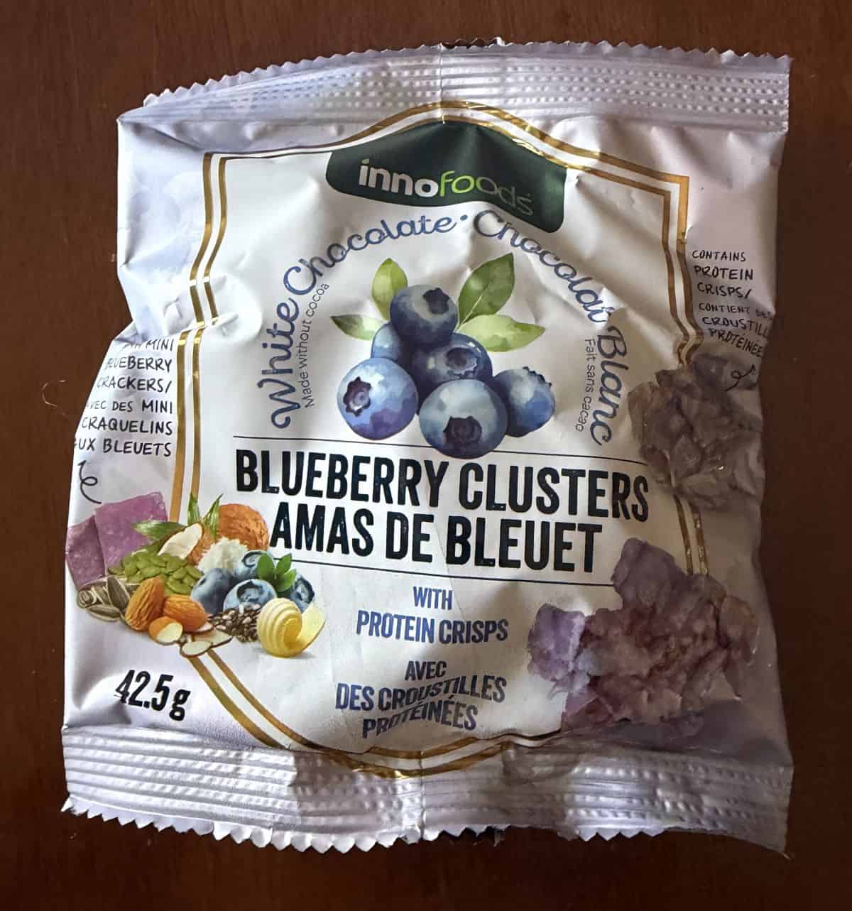 Image of one packed of blueberry clusters unopened sitting on a table.