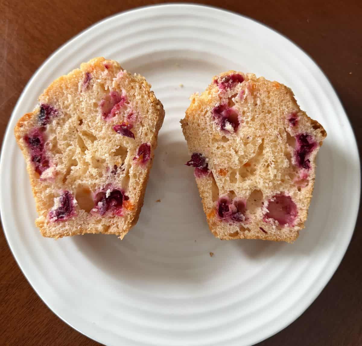 Image of one cranberry orange muffin cut in half so you can see the inside of the muffin.