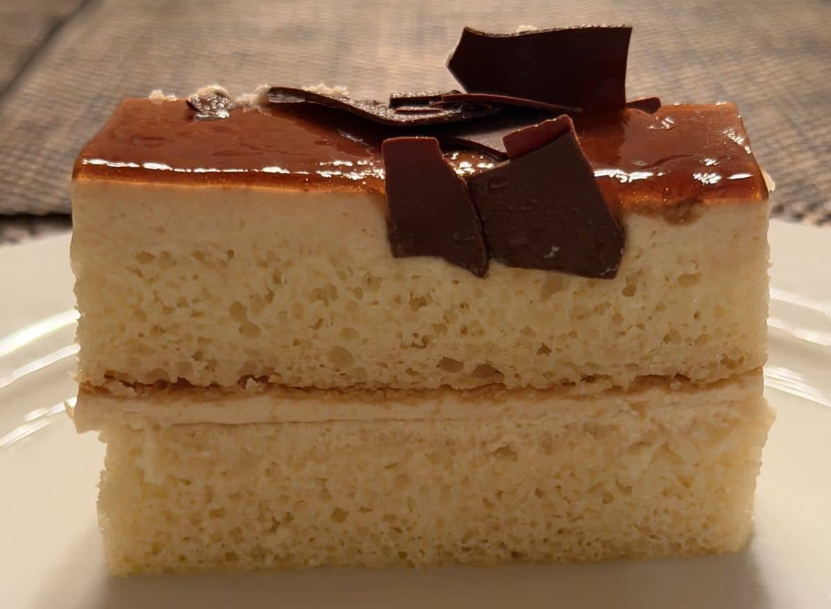 Closeup image of one slice of cake standing on a white plate so all the layers are visible.