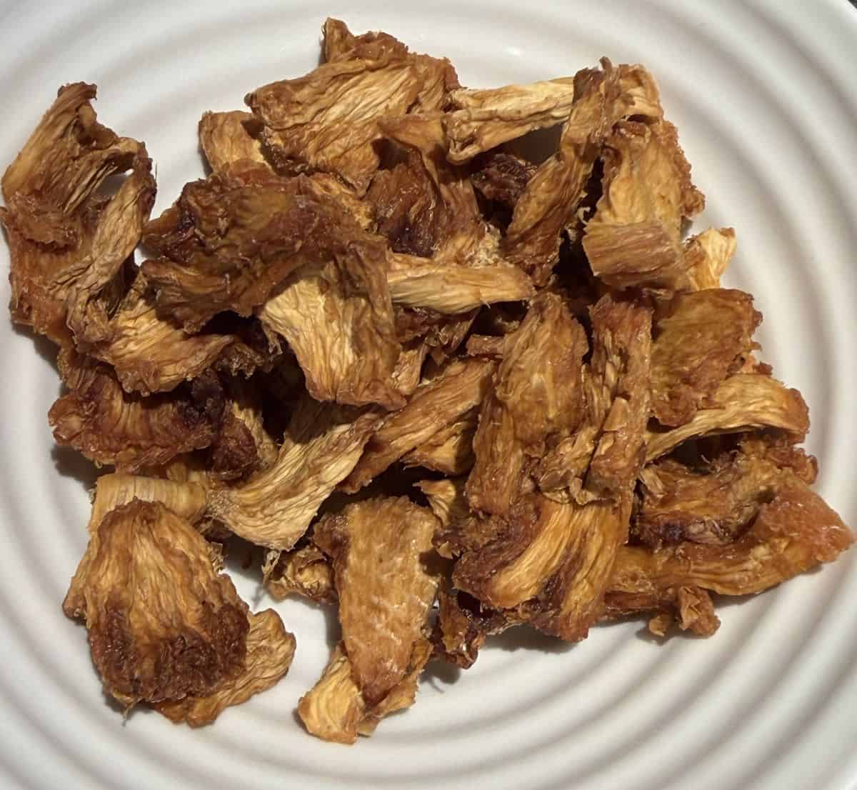Top down image of the dried pineapple served in a white bowl.