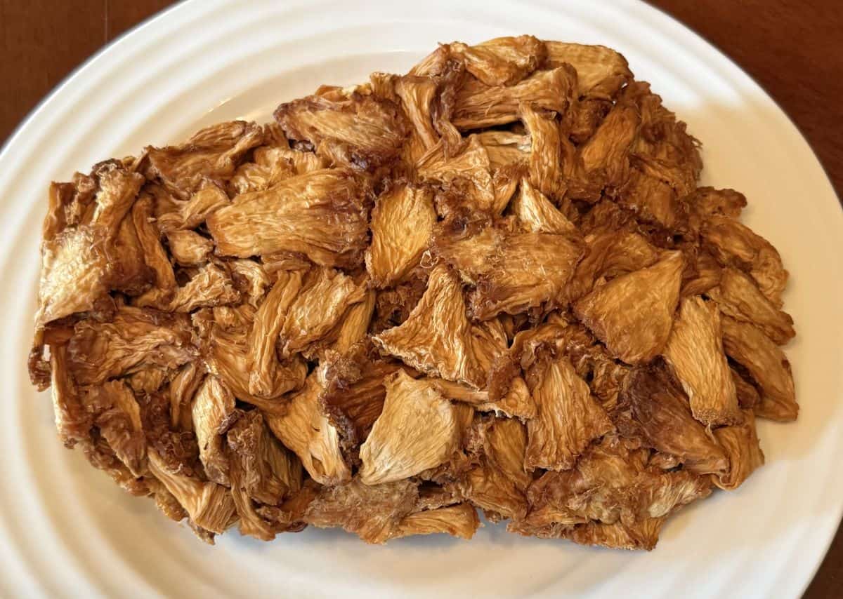 Top down image of one giant mound of dried pineapple pieces all stuck together on a white plate.