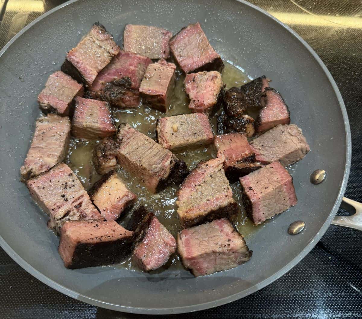 Image of the burnt ends being heated in a pan on the stove.