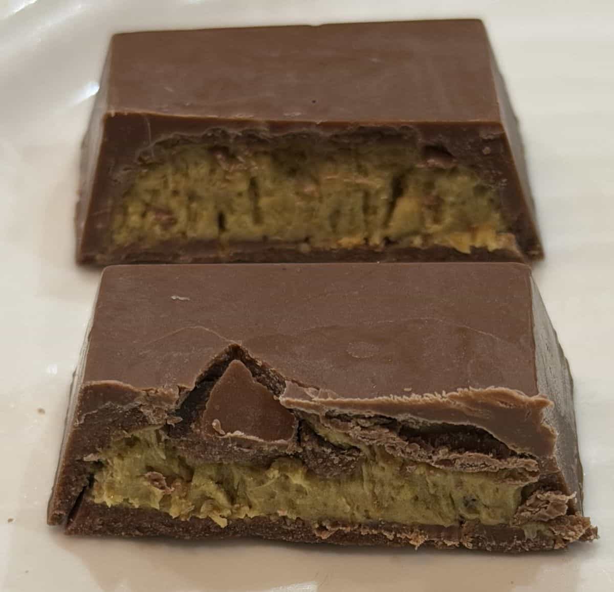 Closeup image of one chocolate cut in half and served on a white plate so you can see the inside of the both chocolates.