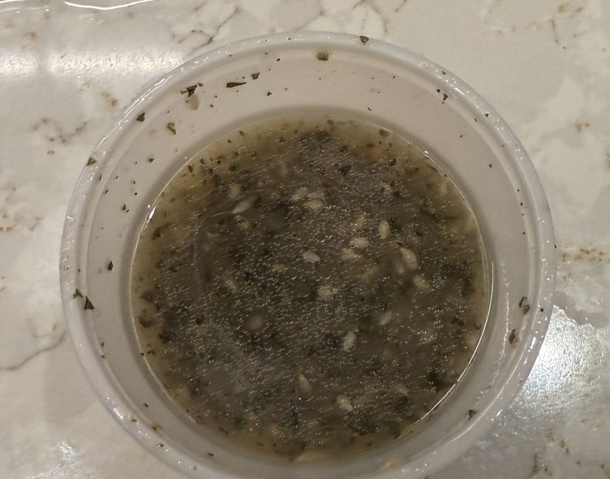 Top down image of an open container of the cilantro lime marinade that comes with the steak.