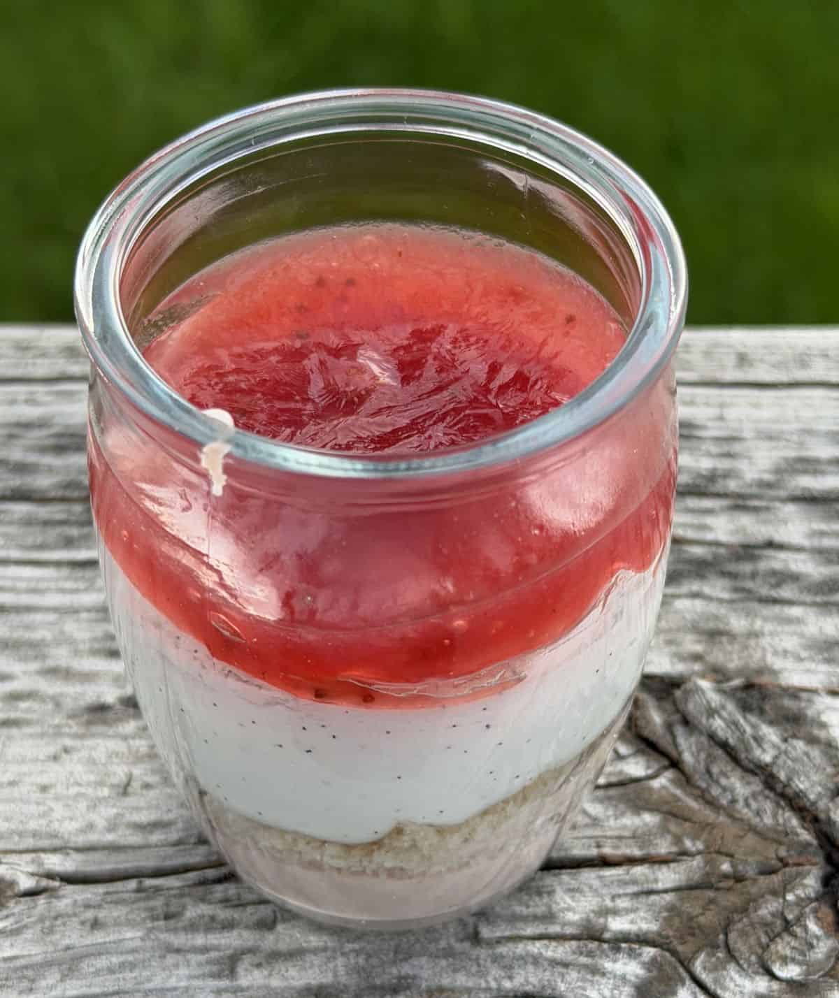 Closeup image of one strawberry shortcake mousse with the lid off so you can see all the layers.
