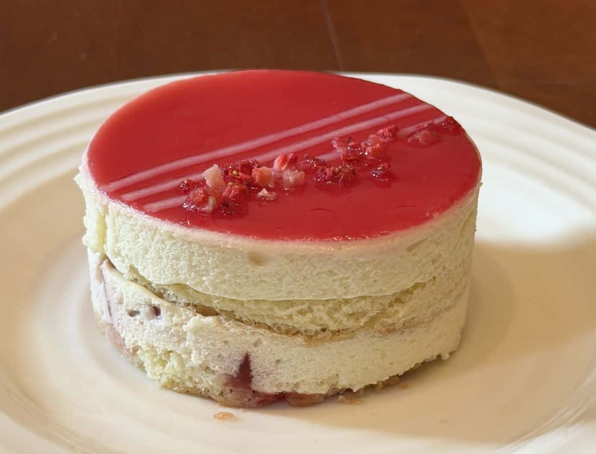 Image of one white chocolate strawberry mousse cake served on a white plate.