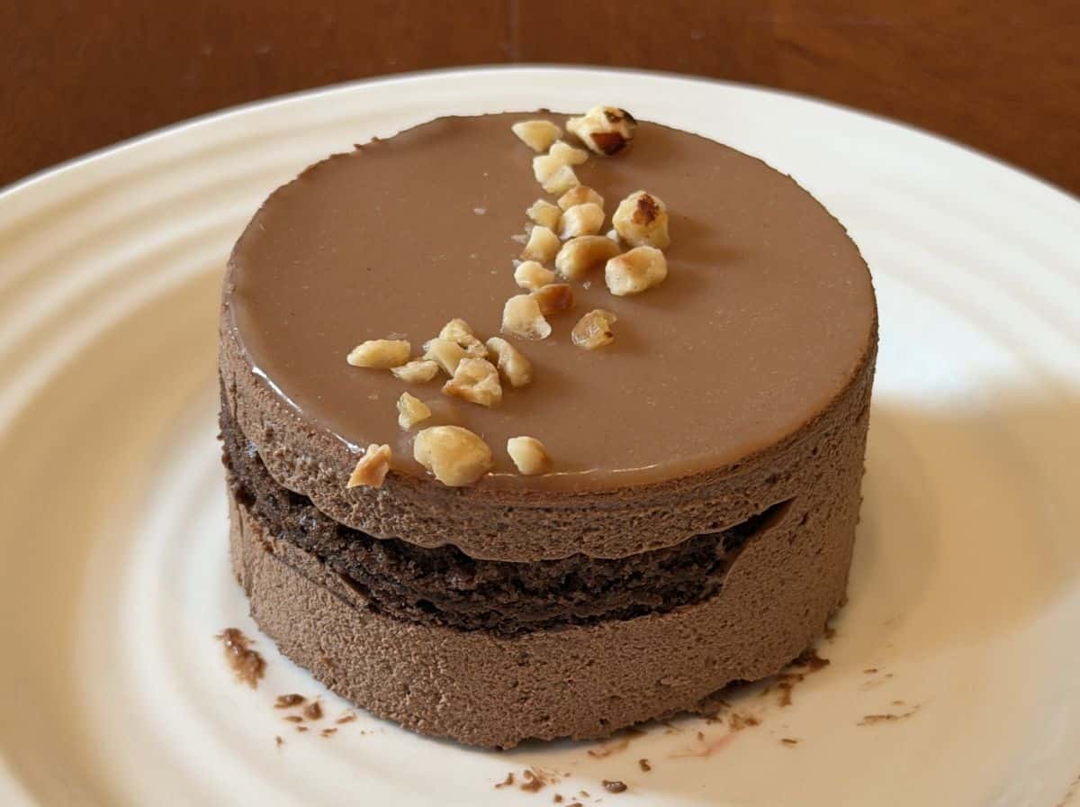 Closeup image of one hazelnut mousse cake served on a white plate.