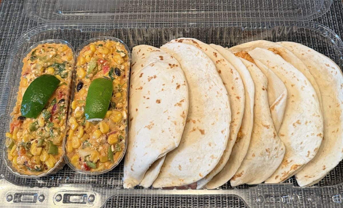 Image of the Costco Kirkland Signature Quesadillas and Mexican Style Corn Salad pre-made meal sitting on a table opened so you can see the contents.