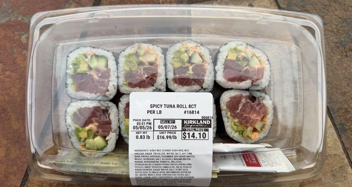 Image of an unopened spicy tuna roll served plastic tray sitting on a table.