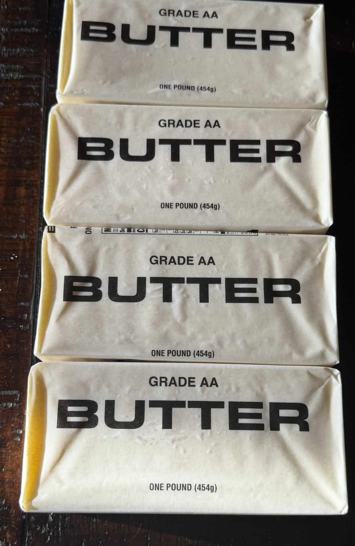 Image of four individually wrapped pounds of butter sitting on a table.