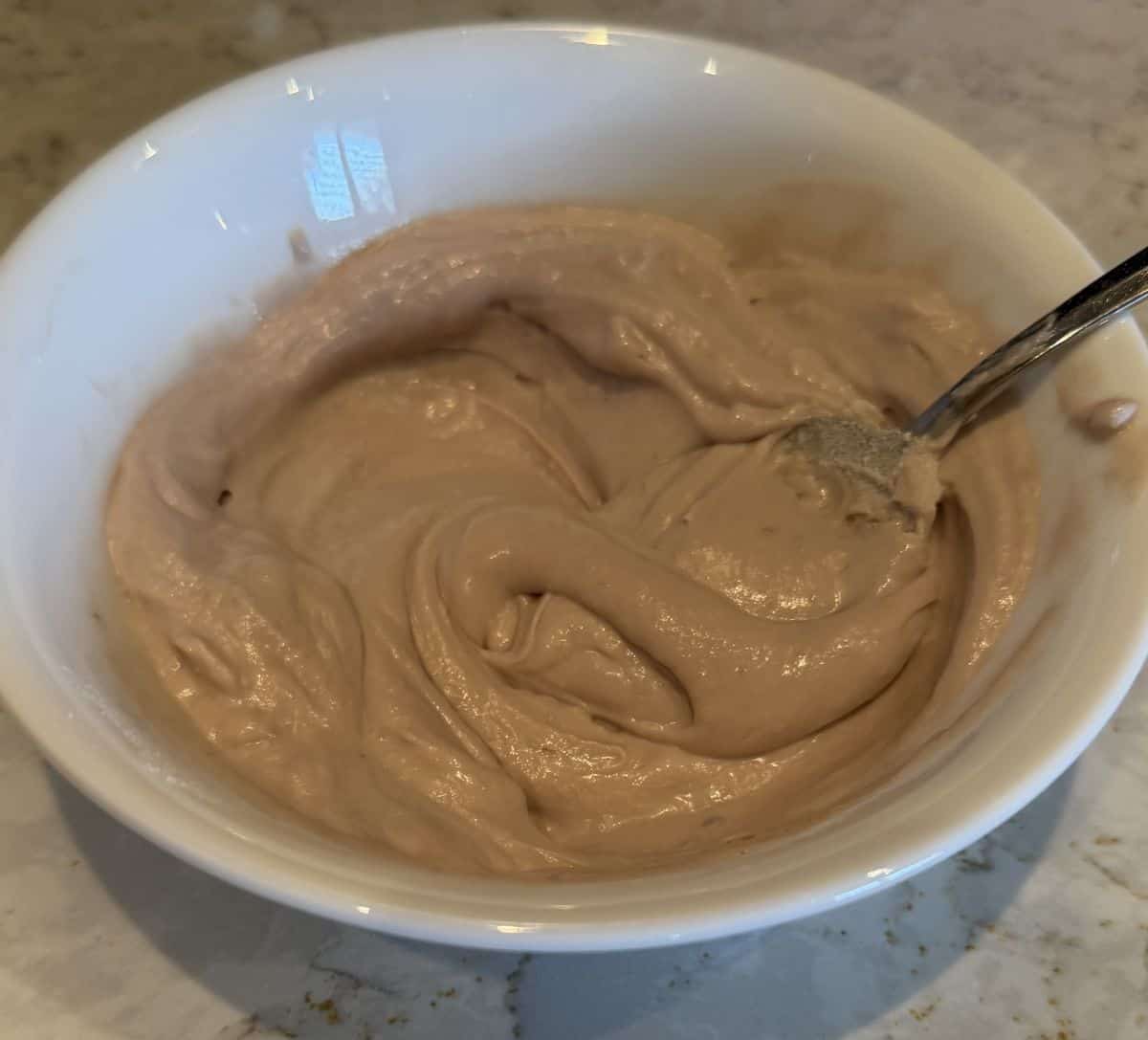 Image of a with bowl with raspberry Cocojune yogurt in it.