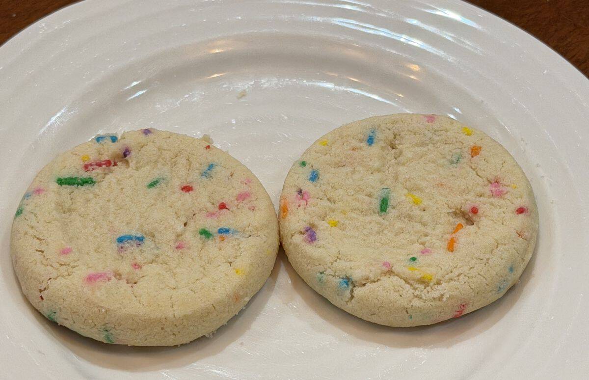 Closeup top down image of two cookies served on a white plate.