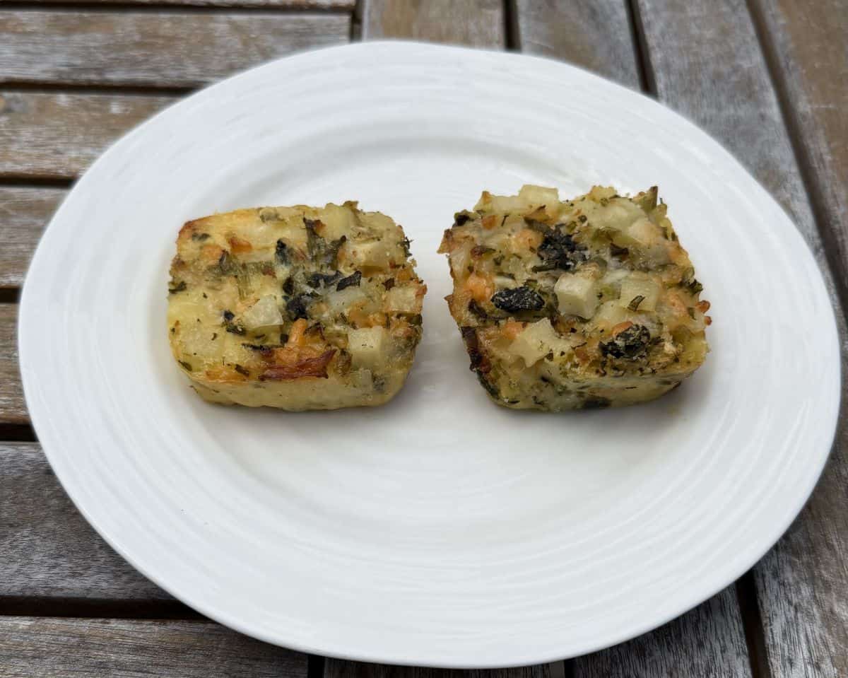 Sideview image of two potato bakes served on white plate.