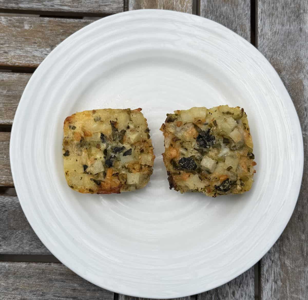 Image of two cooked potato bakes served on a white plate.