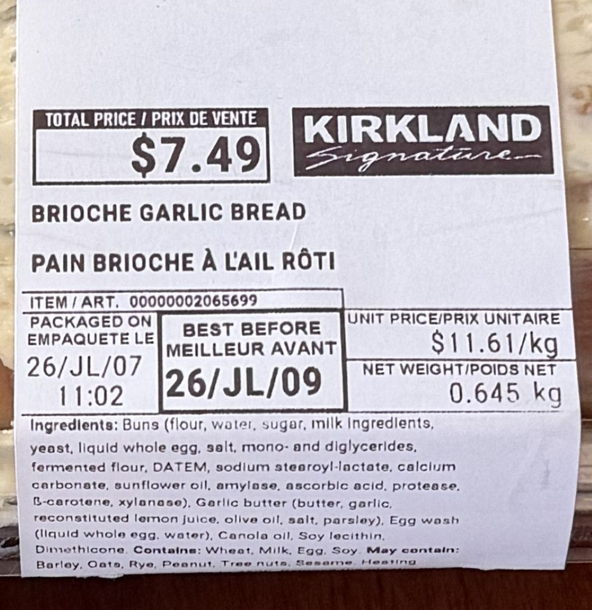 Closeup image of the front label of the brioche garlic bread showing the cost and best before date.