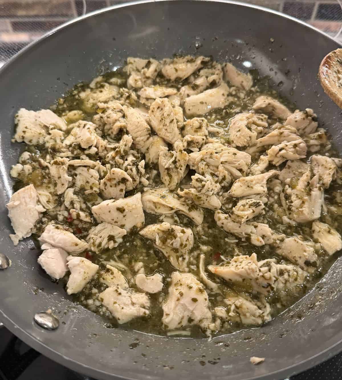 Image of the chicken being heated in a pan.