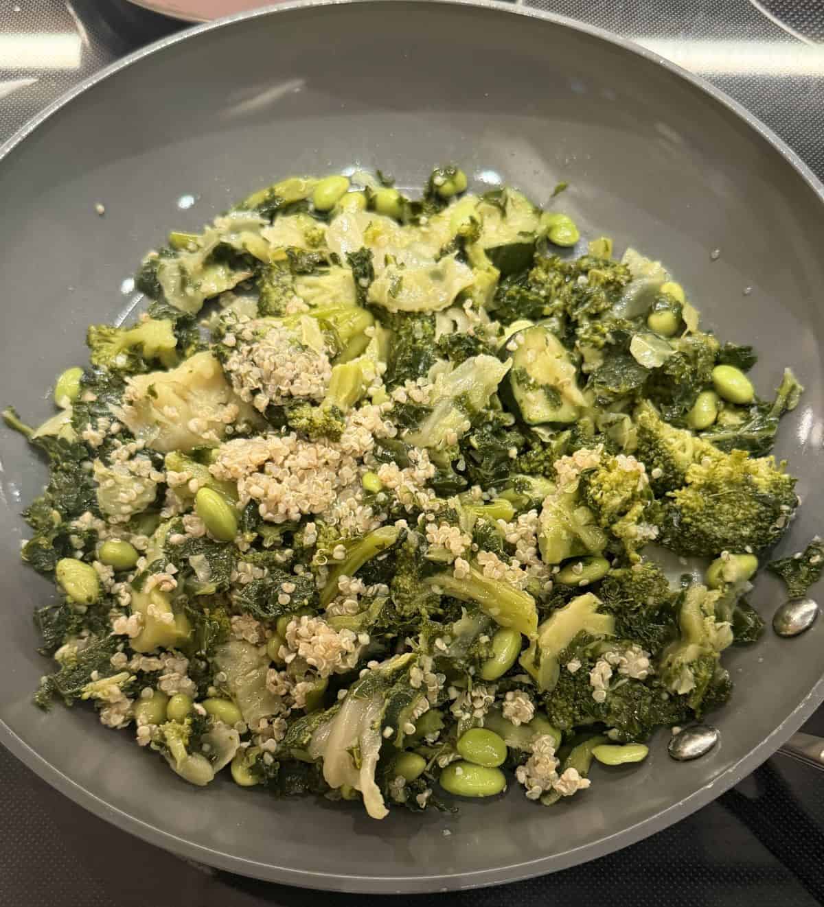 Image of the veggie & quinoa mix being heated in a skillet.