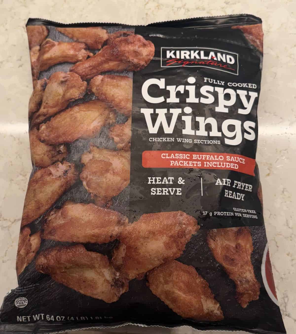 Image of the Costco Kirkland Signature Fully Cooked Crispy Wings bag sitting on a table unopened.