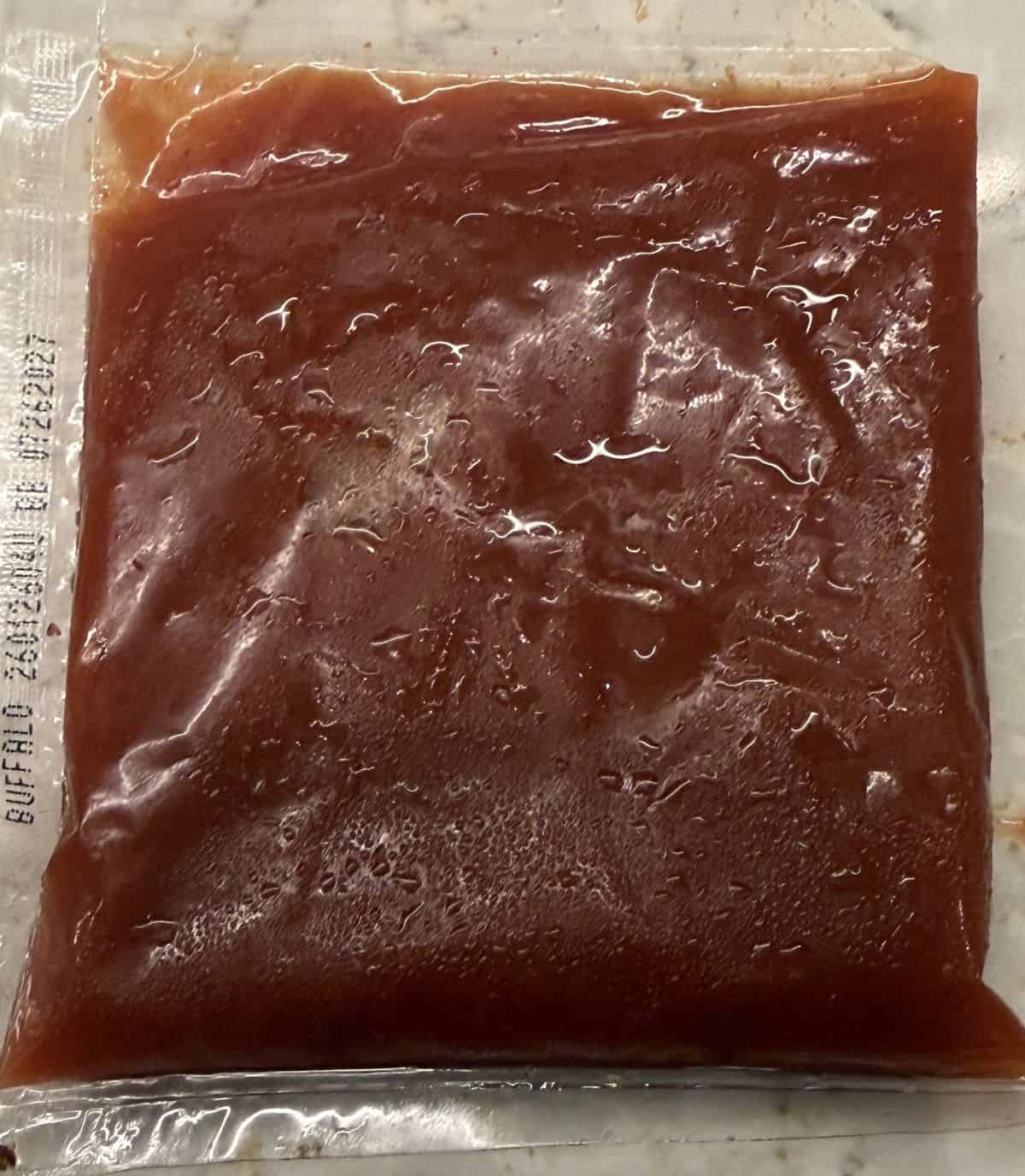 Image of an unopened packet of buffalo sauce sitting on a counter.
