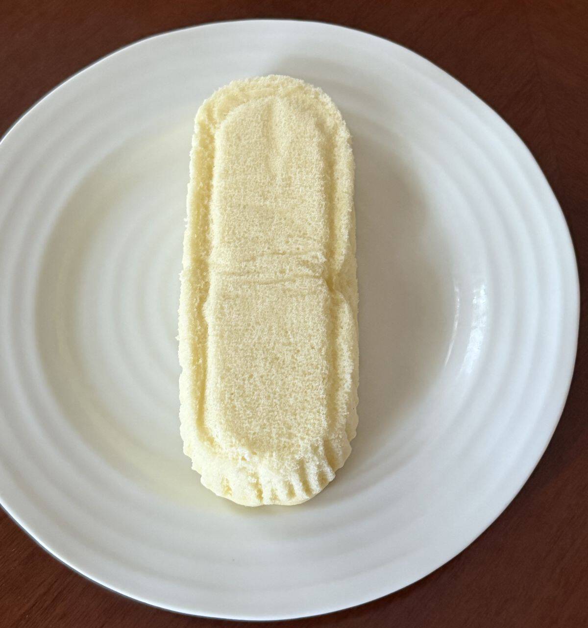 Top down image of one individual soft cheesecake served on a white plate.